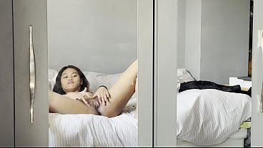 Emma P, une jeune ado asiatique toute menue, applique de la crème sur sa chatte rasée.